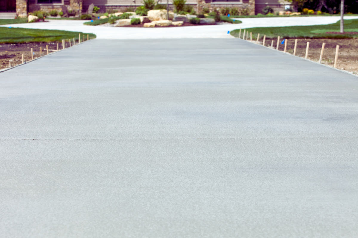 Freshly poured plain grey concrete driveway
